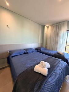 two beds in a room with towels on them at BobZ Concept in Barrinha +7 photos