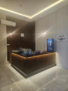 a lobby with a bar with a clock on the wall at أجنحة توليب للشقق المخدومة in Hafr Al-Batin +29 photos