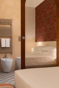 a bedroom with a bed and a tub and a sink at Palazzo Gulino in Palma di Montechiaro +34 photos