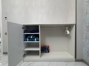 a small white cupboard in a room at Alvina Private Yard Apartment in Tsaghkadzor