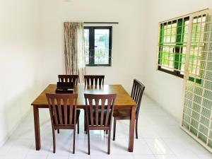 a dining room with a wooden table and chairs at 365 House by D'Laksamana in Malacca