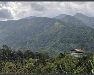 a house on a hill with mountains in the background at Cliffhouse Kalinga in Tinglayan