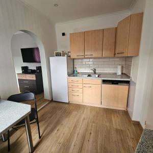 a kitchen with a white refrigerator and wooden cabinets at Gartenblick Trebbin in Trebbin