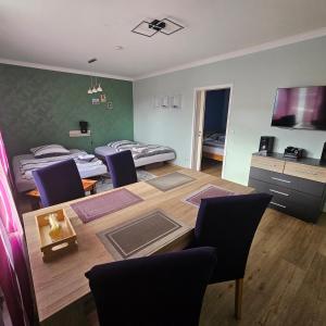a room with a table and chairs and a bedroom at Gartenblick Trebbin in Trebbin