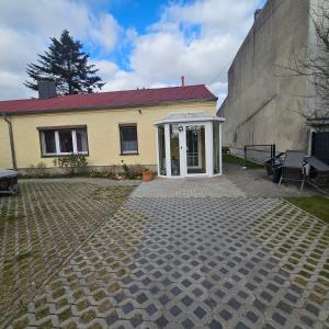 a yellow house with a brick driveway in front of it at Gartenblick Trebbin in Trebbin