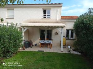 a patio with a table and an awning on a house at villa Montecristo in Cervione