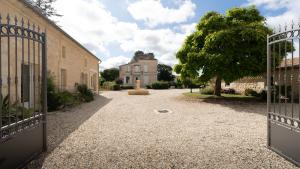 an open gate to a building with a fountain at Château Clos des Maurins in Vérac
