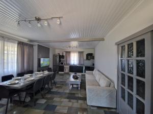 a living room with a long table and a couch at Green Garden Private Villa in Porto Heli