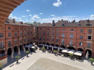 an empty courtyard in a large brick building at Maison au calme proche accès rocade in Montauban