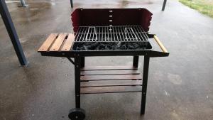 a barbecue grill sitting on a table in the rain at Duplex avec vue au centre de Bussang in Bussang