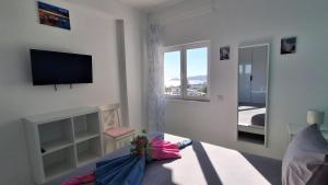 a living room with a tv and a couch at Da Rocha Beach 50M, AMAZING Sunset SEA VIEW in Portimão