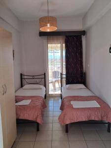 two beds in a room with a balcony at Villa Marili in Paralia Katerinis
