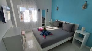 a blue bedroom with a bed with some items on it at Da Rocha Beach 50M, AMAZING Sunset SEA VIEW in Portimão +18 photos
