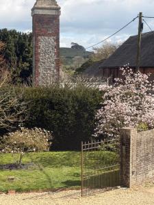 a fence in front of a house with pink flowers at The Bothy in Pewsey +25 photos