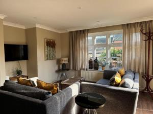 a living room with two couches and a tv at Scarborough Hill Country Inn in North Walsham