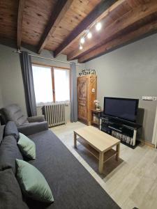 a living room with a couch and a tv at Maison de campagne in Picherande