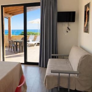 a hotel room with a bed and a view of the ocean at Cala Greca Case Vacanze in Capo Rizzuto