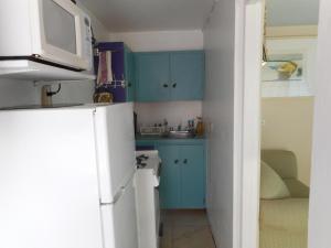 uma cozinha com armários azuis e um frigorífico branco em Blue Horizons Guest House em Hamilton