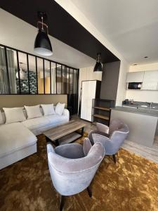 a living room with a couch and chairs and a table at Au Saint Martin in Cholet