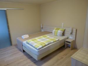 Dormitorio pequeño con cama y mesa en Pension Zur Eiche en Drebenstedt