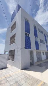 a white building with blue solar panels on it at Apartamento em Jacumã in Conde