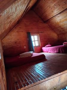a room with two beds in a wooden cabin at Chalé Nascer do Sol in São Thomé das Letras