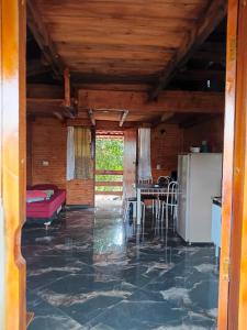 a living room with a refrigerator and a table at Chalé Nascer do Sol in São Thomé das Letras