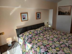 a bedroom with a bed with a floral bedspread at Bellavista garden and flowers in Varenna