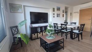 a living room with a dining table and a television at Ta World apartments in Spodnji Log