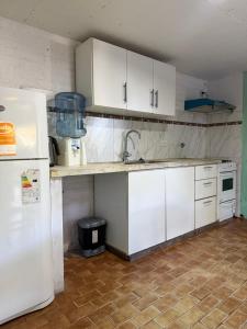 a kitchen with white cabinets and a white refrigerator at Lo de Nery in Ostende