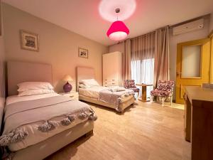 a bedroom with two beds and a pink light at Bab louka in Aït Bou Zguia +88 photos