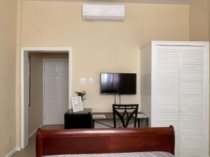 a bedroom with a bed and a tv on a wall at The Colosseum St Kitts in Basseterre