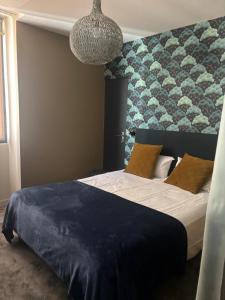 a bedroom with a bed with a large wall at Au Saint Martin in Cholet