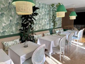 a restaurant with white tables and chairs and green walls at Bab louka in Aït Bou Zguia