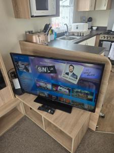 a flat screen tv sitting on a stand in a kitchen at F86 Steeple Bay in Steeple