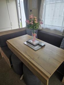 a wooden table with a vase with flowers on it at F86 Steeple Bay in Steeple