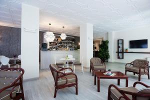 una sala d'attesa con sedie e tavoli e un bar di Olimpia Hotel & Aparthotel a Bibione