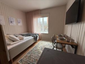 a bedroom with a bed and a table and a window at Jakobsoni 15 Apartmendid in Viljandi