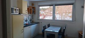 a small kitchen with a table and a window at Evasion Gérardmer in Gérardmer