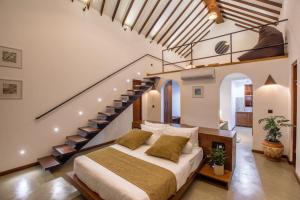 a bedroom with a large bed with a staircase at Avora Lake Villas in Anuradhapura +38 photos