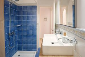 a bathroom with a white sink and a shower at Fereniki's place in Gaios +26 photos