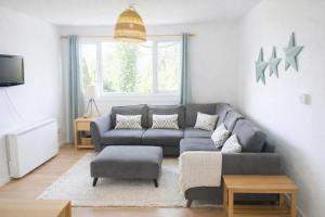 a living room with a gray couch and a tv at Hillside Chalet in Kilkhampton