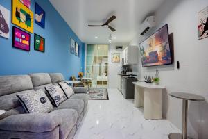 a living room with a couch and a blue wall at Only U Home-Stay Villa Huahin in Hua Hin
