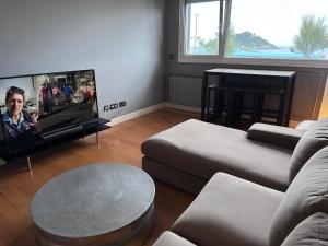 a living room with a couch and a flat screen tv at Samsara in San Sebastián