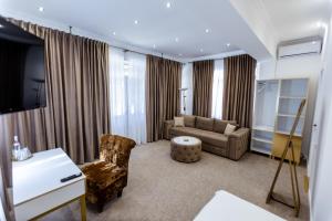 a living room with a couch and a chair at Jolie Boutique Hotel Corp B in Craiova