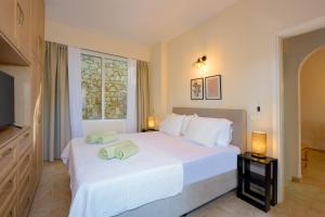 a bedroom with a white bed with towels on it at Fereniki's place in Gaios