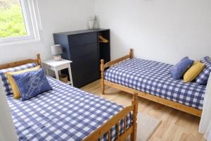 a bedroom with two beds and a dresser at Hillside Chalet in Kilkhampton