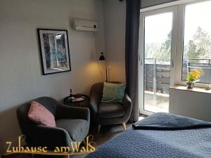 a bedroom with a bed and a chair and a window at Zuhause Am Wald in Brilon