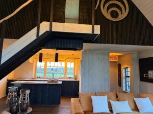 a living room with a couch and a kitchen at Rust en natuur in de Vlaamse Ardennen in Kluisbergen