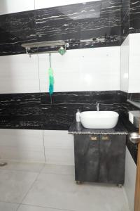 a bathroom with a sink and a black and white wall at Aashray in Dehradun +6 photos